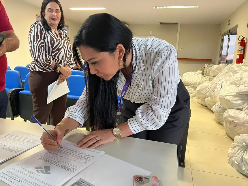 Coordenadora do Cram, Nátane Oliveira assinando o termo de cooperação 