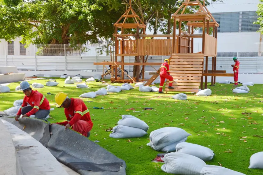 Área do lazer para famílias, setor do parque infantil recebe grama sintética e parquinho