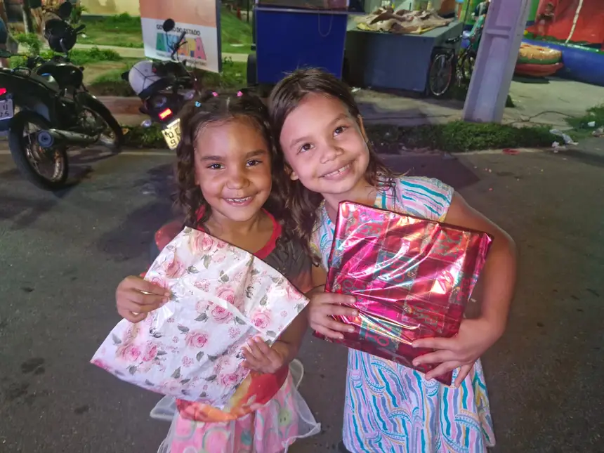 As amigas Débora Oliveira (à direita) e Emily Pietra (à esquerda) receberam brinquedos do Papai Noel durante a festividade