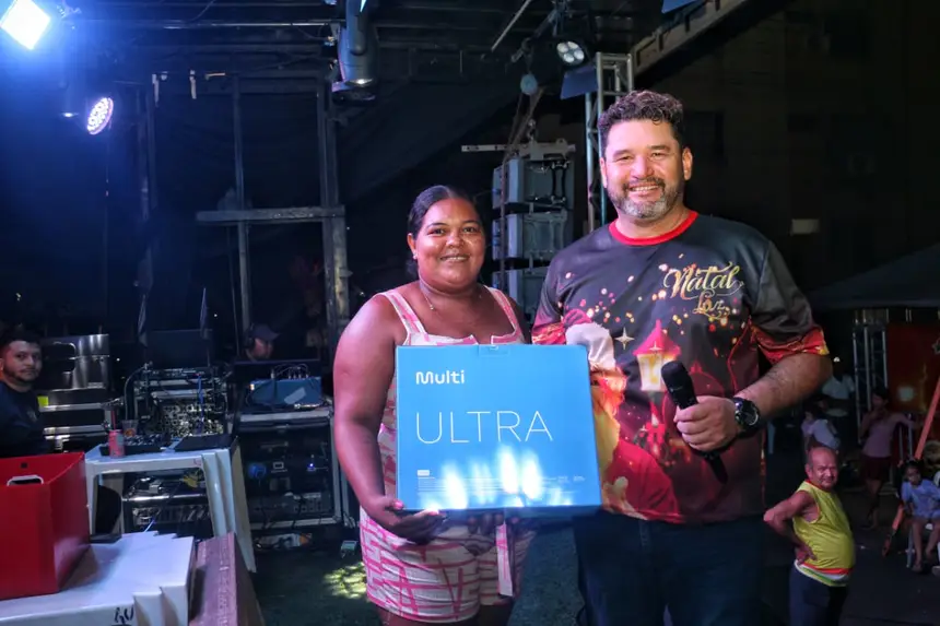 Moradora contemplada com um notbook por meio de um bingo 